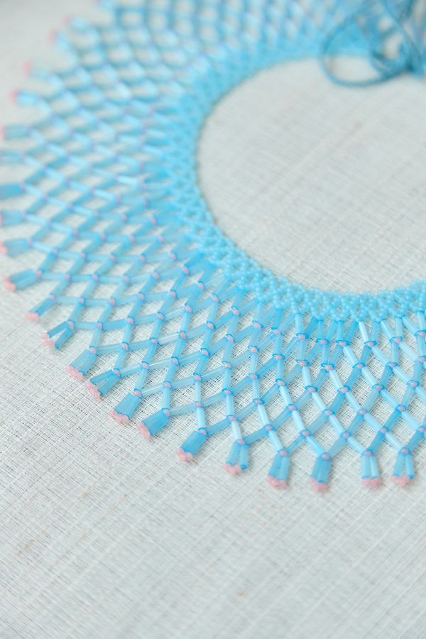 A glass bead necklace, blue with pink