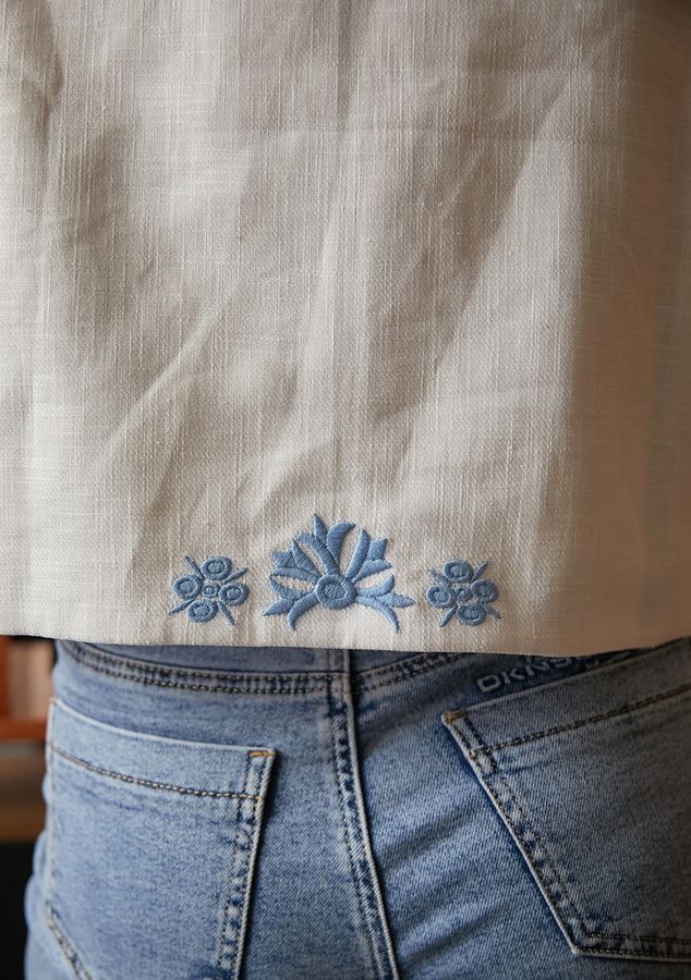 White vest with blue embroidery